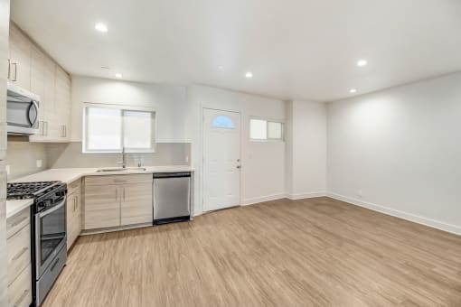 an empty room with a kitchen and a living room