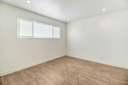 an empty room with white walls and a window