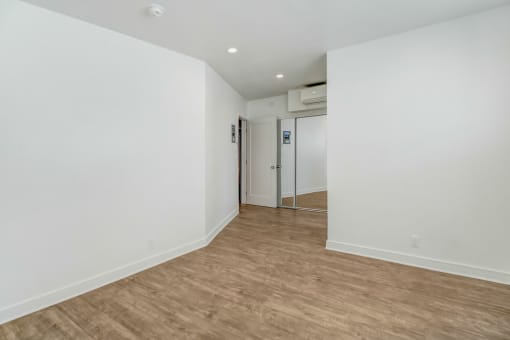 an empty room with white walls and a wooden floor