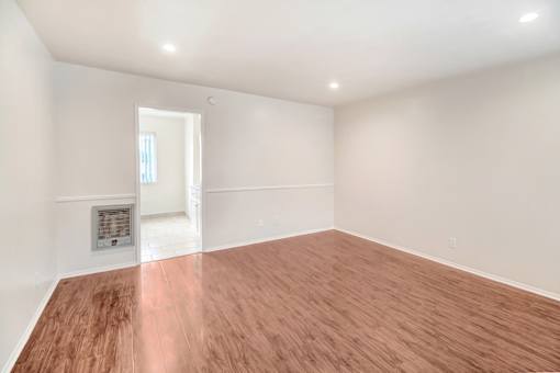 A room with wooden flooring and a fireplace.