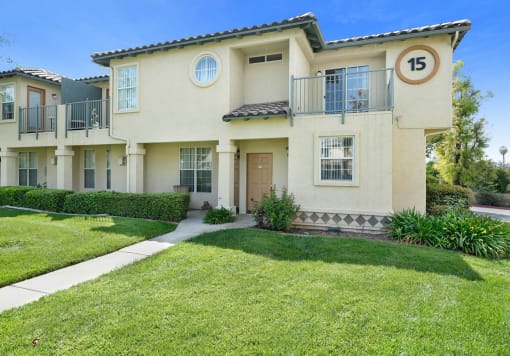 a house with a lawn and a sidewalk in front of it