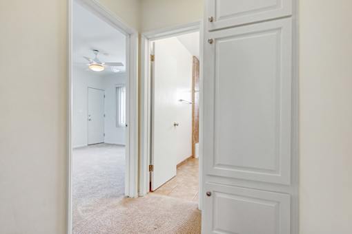 a bedroom with a door to a hallway and a closet