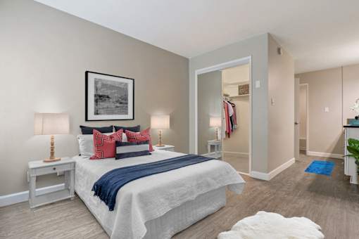 Bedroom with a mirrored closet doors, wood-inspired floors