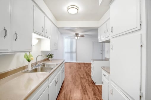 a white kitchen with white cabinets and a wood floor