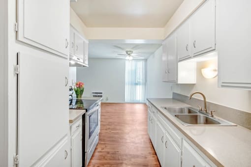 a large kitchen with white cabinets and a sink