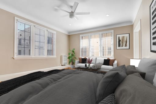 a bedroom with a large bed and a couch and a ceiling fan