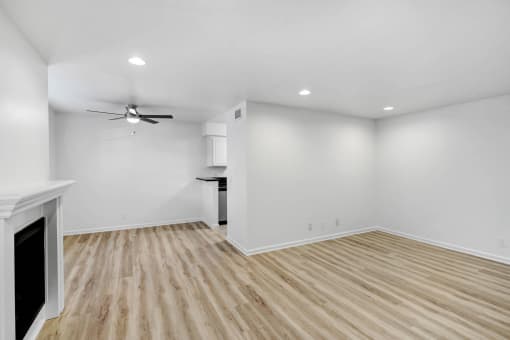 an empty living room with white walls and wood flooring