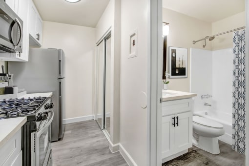a renovated kitchen with white cabinets and a stainless steel refrigerator