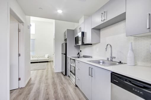 Beautiful Kitchen with stainless steel appliances including two-door refrigerator, dishwasher, microwave, electric range, Quartz Countertops, tile backsplash, wood style floors