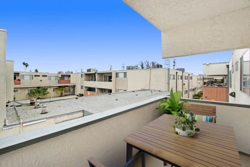 a balcony with a wooden table and a view of buildings