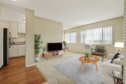 Living room with carpeted floors and Kitchen area with wood inspired floors