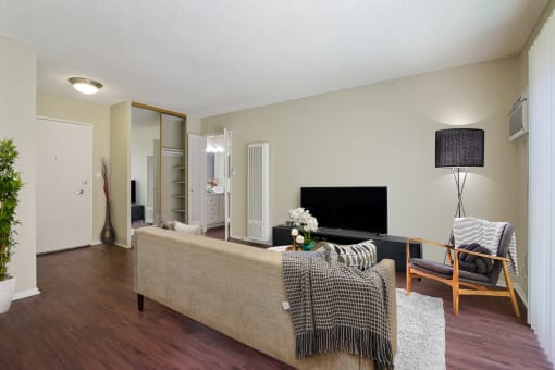 Wood-inspired floors in living room with a mirrored closet doors