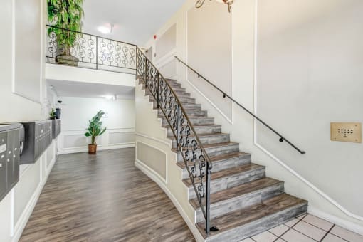 the foyer of a house with stairs and a railing and a plant