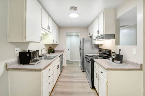 a large kitchen with white cabinets and stainless steel appliances