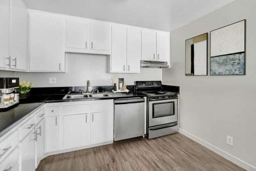 an empty kitchen with white cabinets and stainless steel appliances