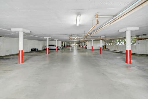 an empty parking garage with red and white poles