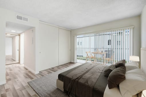 a bedroom with a bed and a sliding glass door