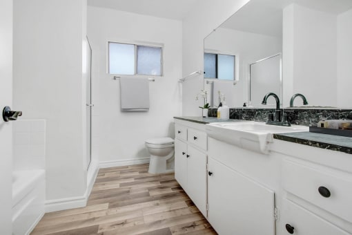 a bathroom with white cabinets and a sink and a toilet