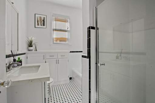 a white bathroom with a shower and a sink