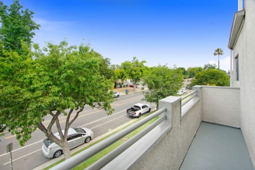 a view of a parking lot from a balcony with cars on the street