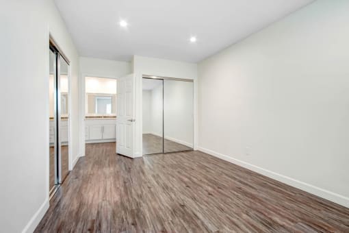 a living room with a mirror and a wooden floor