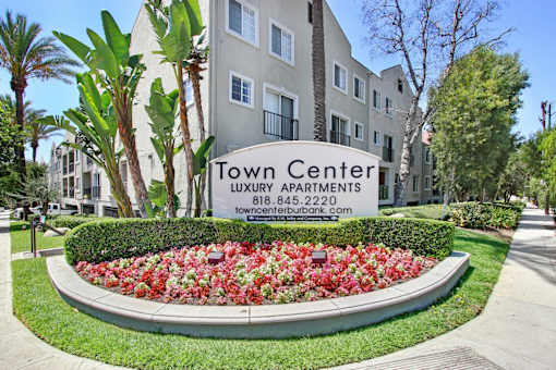 A sign for Town Center Luxury Apartments is in front of a building.