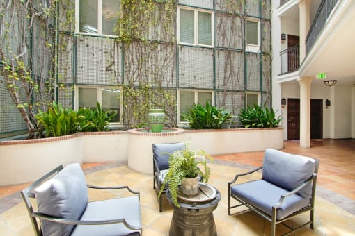 a patio with chairs and a table in front of a building