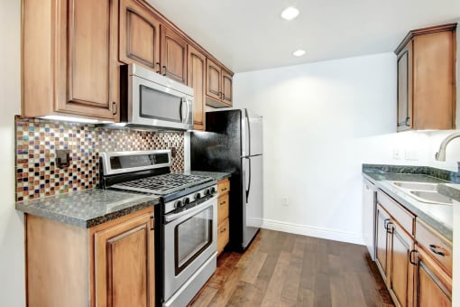 a kitchen with wooden cabinets and stainless steel appliances