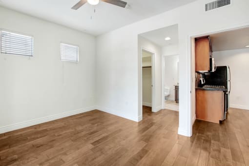 a living room with a kitchen and a hard wood floor
