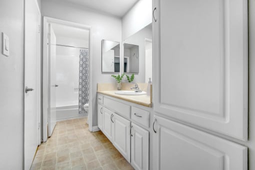 a white bathroom with a sink and a shower