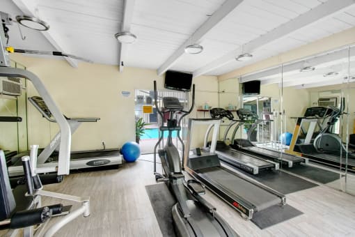 a gym with lots of treadmills and other exercise equipment