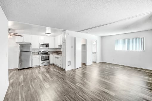 the living room and kitchen of an apartment with stainless steel appliances