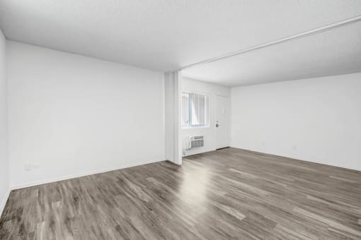 an empty living room with white walls and wood floors
