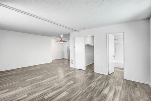 an empty living room with white walls and wood flooring