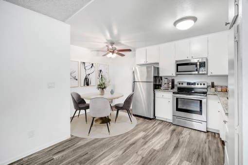 a kitchen with white appliances and a dining table