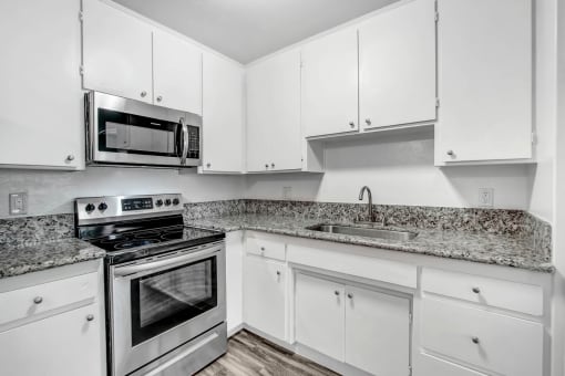 a kitchen with white cabinets and stainless steel appliances