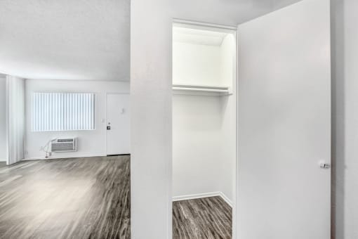 an empty living room with white walls and wood flooring