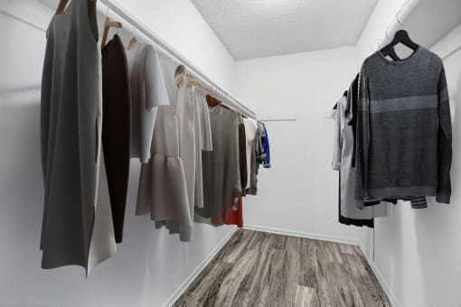 a closet with a rack of clothes hanging on the wall