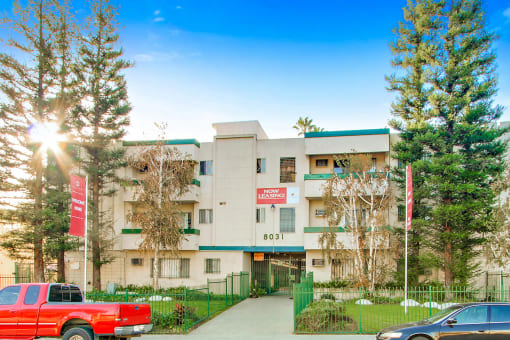 a white apartment building with green trim and a red sign that reads 801