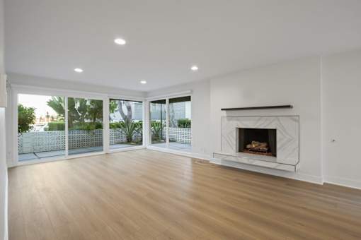 A modern living room with a fireplace and sliding glass doors.