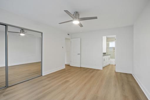 A room with a ceiling fan and a sliding glass door.