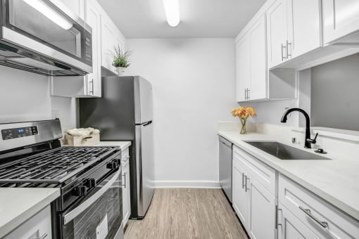 a white kitchen with stainless steel appliances and white cabinets