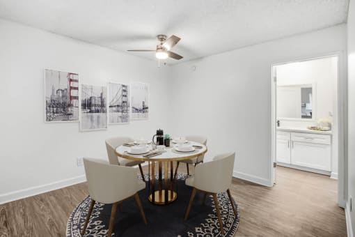 a dining room with a table and chairs and a ceiling fan