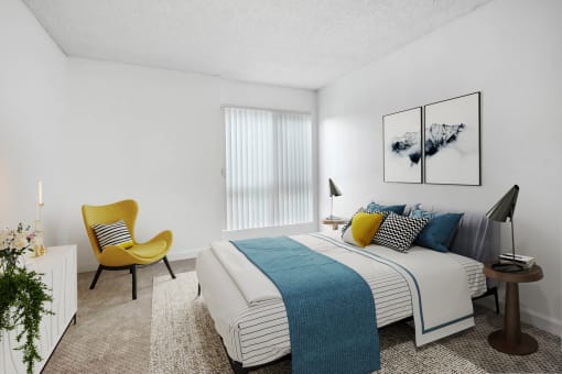 a bedroom with a bed and a yellow chair