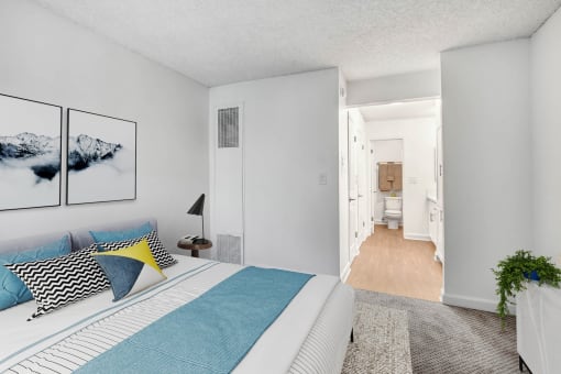 a bedroom with a bed and a view of a bathroom and a hallway