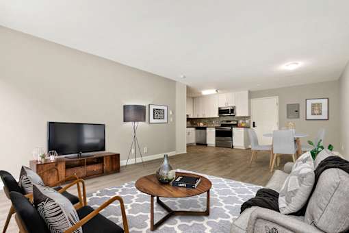 Living room, dining area and an open kitchen with wood-style floors throughout
