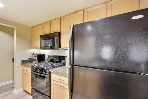 the kitchen has stainless steel appliances and wood cabinets