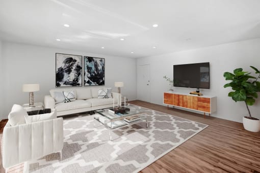 a living room with a white couch and a television