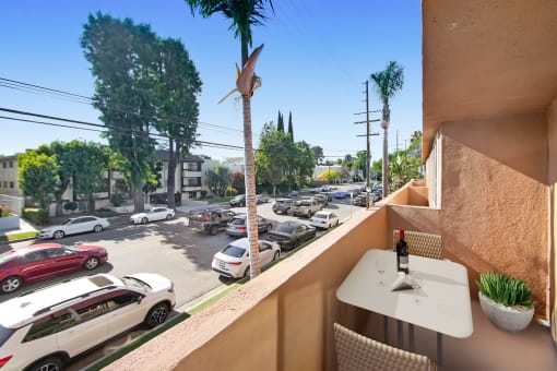a balcony with a table and a view of a parking lot