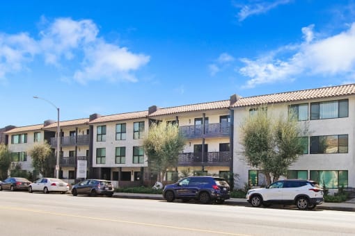 an apartment building on the side of a street with parked cars